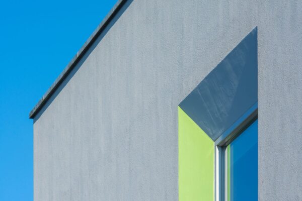 Nahaufnahme einer modernen Gebäudefassade vor einem strahlend blauen Himmel, die das geometrische Design hervorhebt.